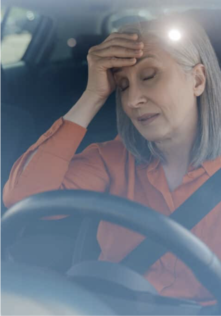 Woman having a migraine wile driving